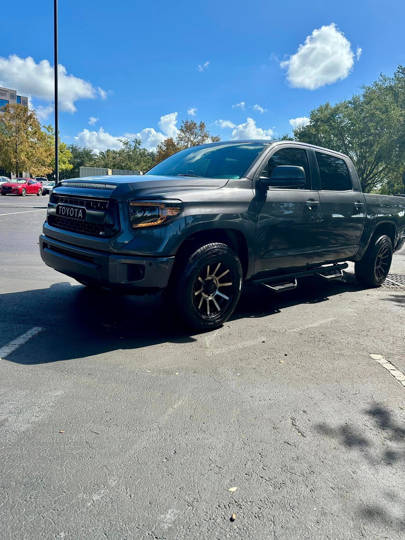 A toyota tundra is parked in a parking lot on a sunny day.