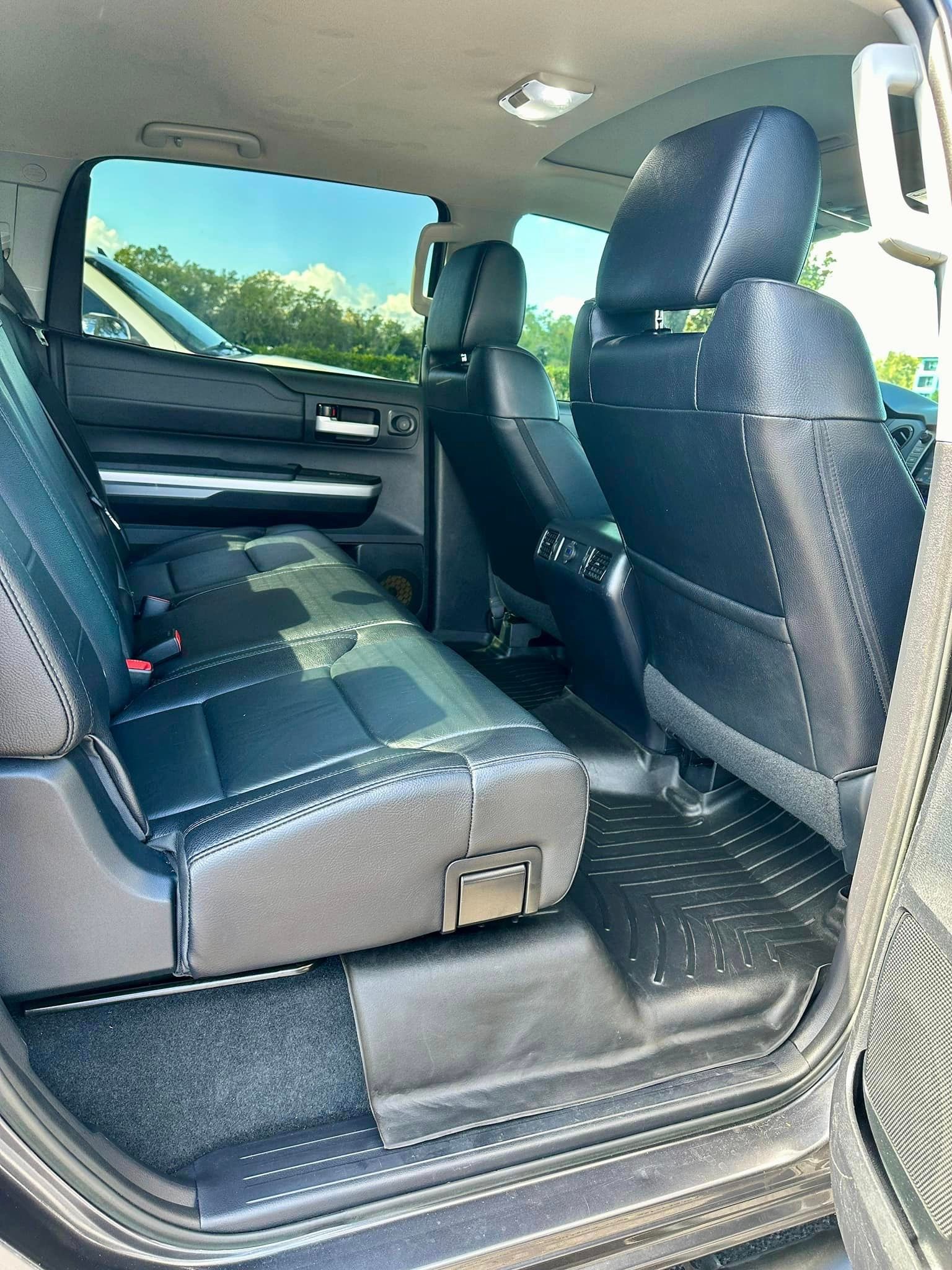 The back seat of a toyota tundra is shown with the door open.
