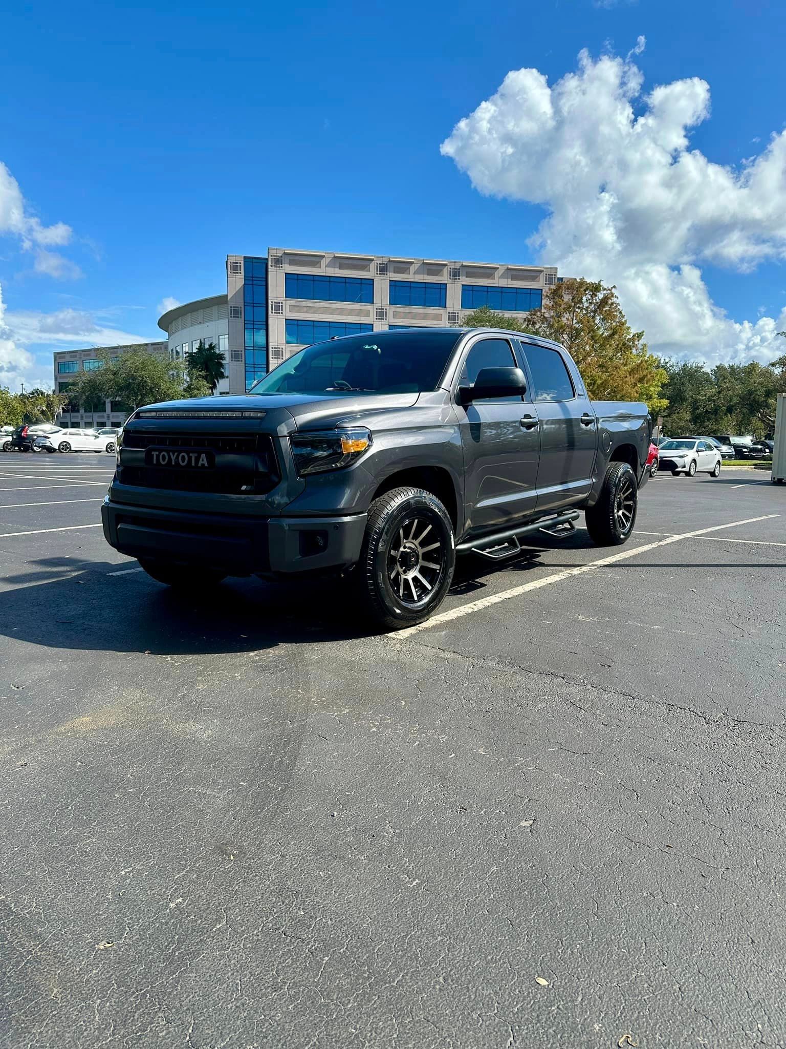 A toyota tundra is parked in a parking lot in front of a building.