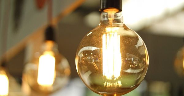 A close up of a light bulb hanging from a ceiling.