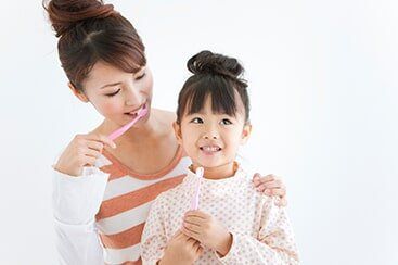 Girl and woman brushing teeth, white background
