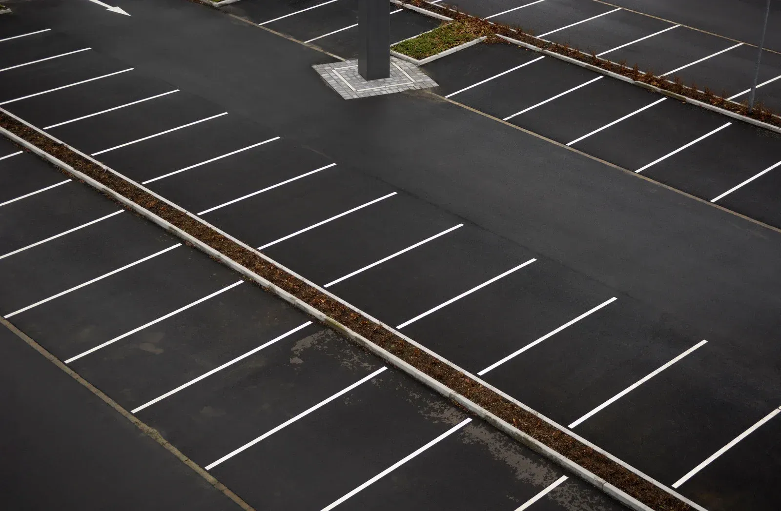 Man in work clothes connecting pipes to a Carrier AC unit on a rooftop.