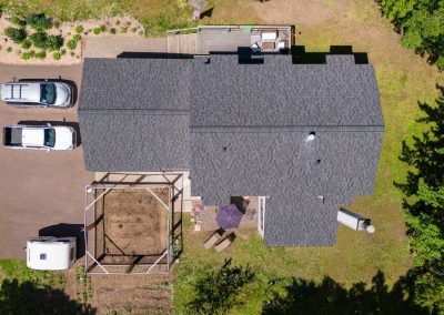 An aerial view of a house with cars parked in front of it.