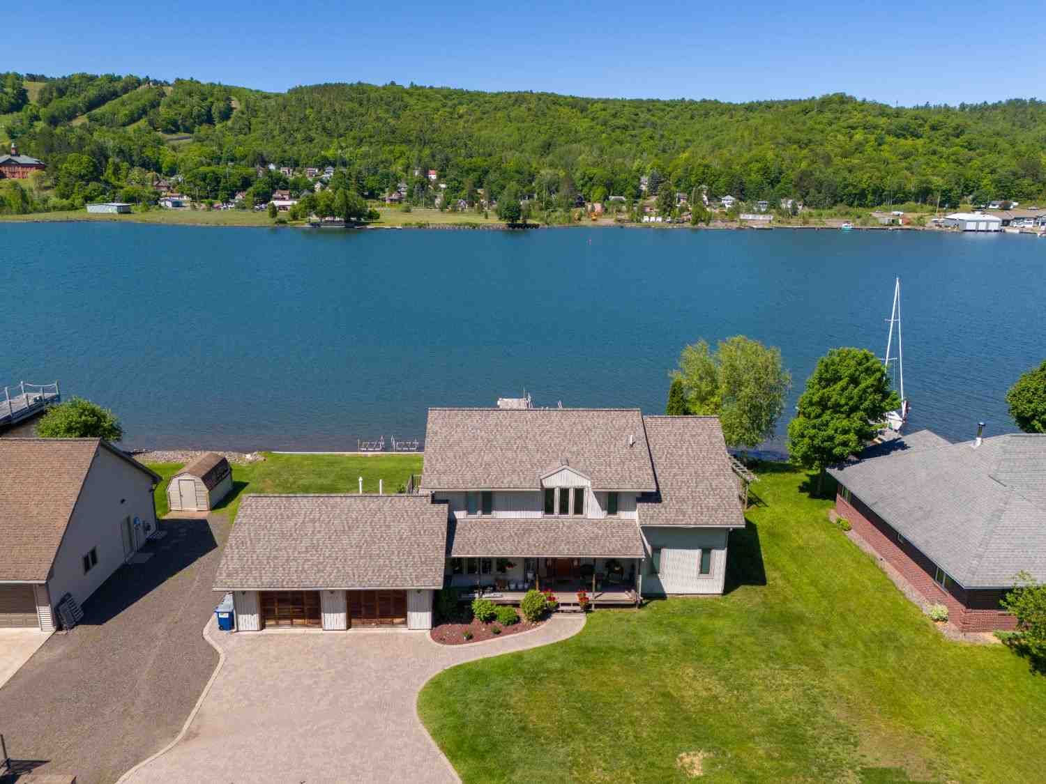 An aerial view of a house on the shore of a lake.