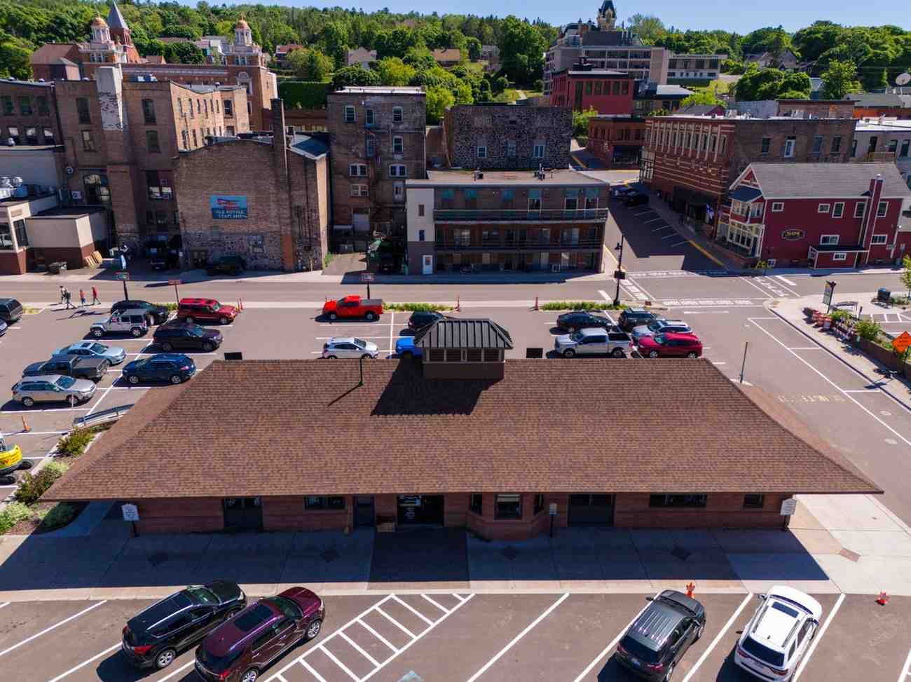 An aerial view of a parking lot with cars parked in front of a building