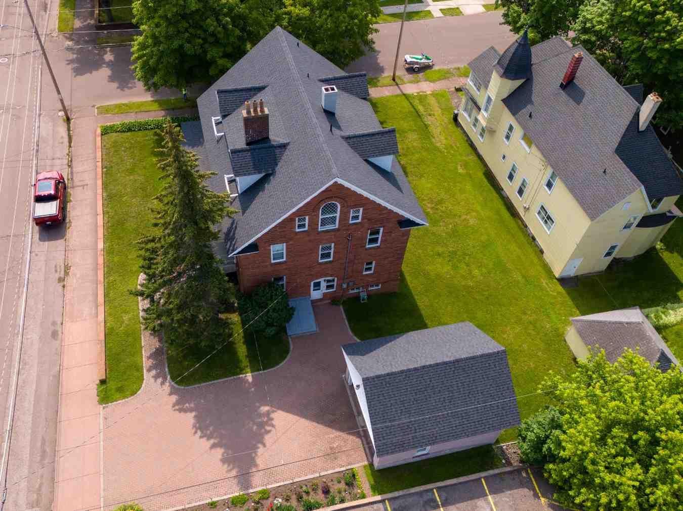 An aerial view of a brick building with a car parked in front of it