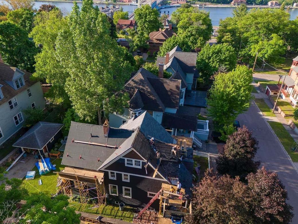 An aerial view of a residential neighborhood with a large black house in the middle.
