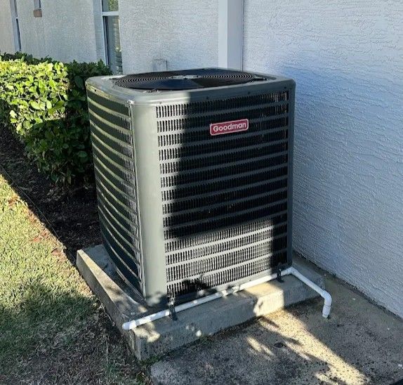 Woman in straw hat smiles, holding wine glass near a lake.