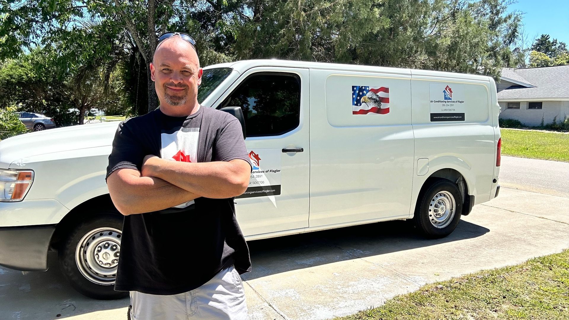 Woman in straw hat smiles, holding wine glass near a lake.