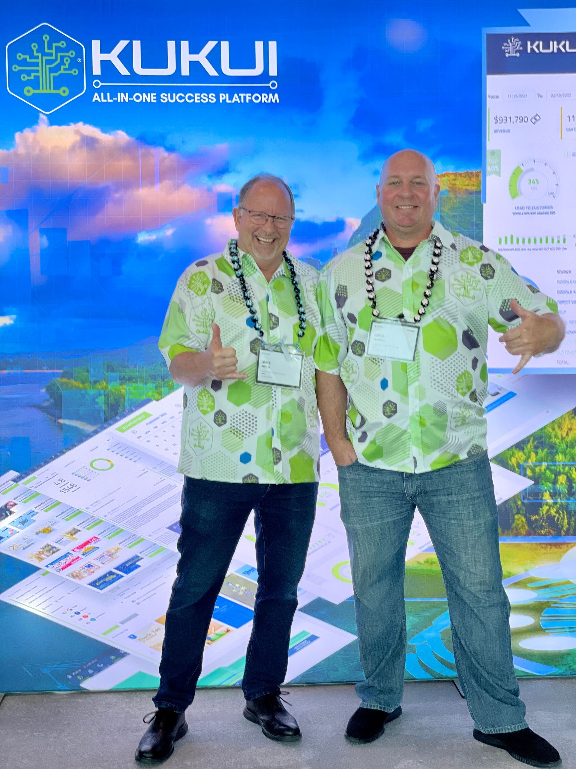 Two men standing in front of a kukui sign