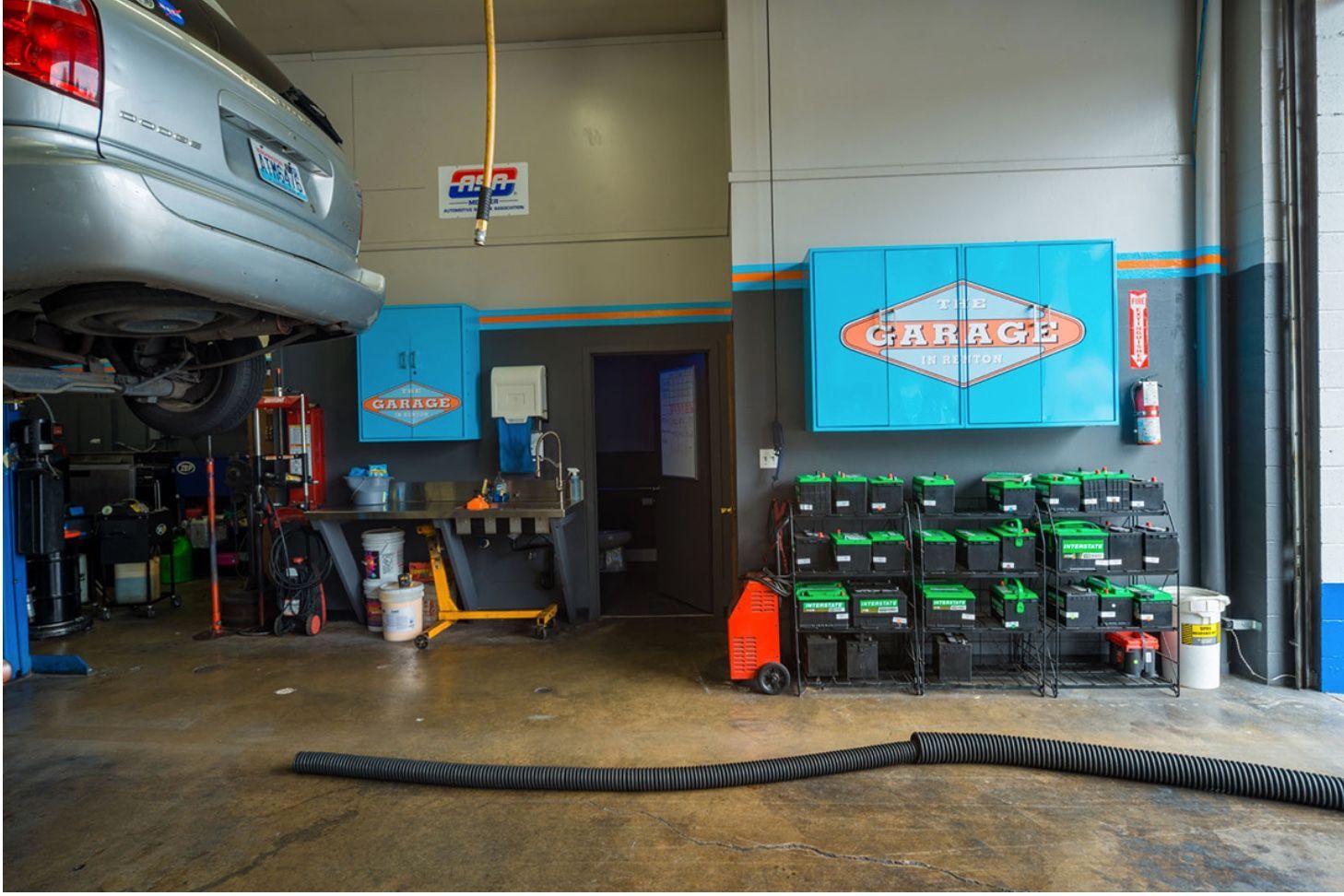 A car is sitting on a lift in a garage.