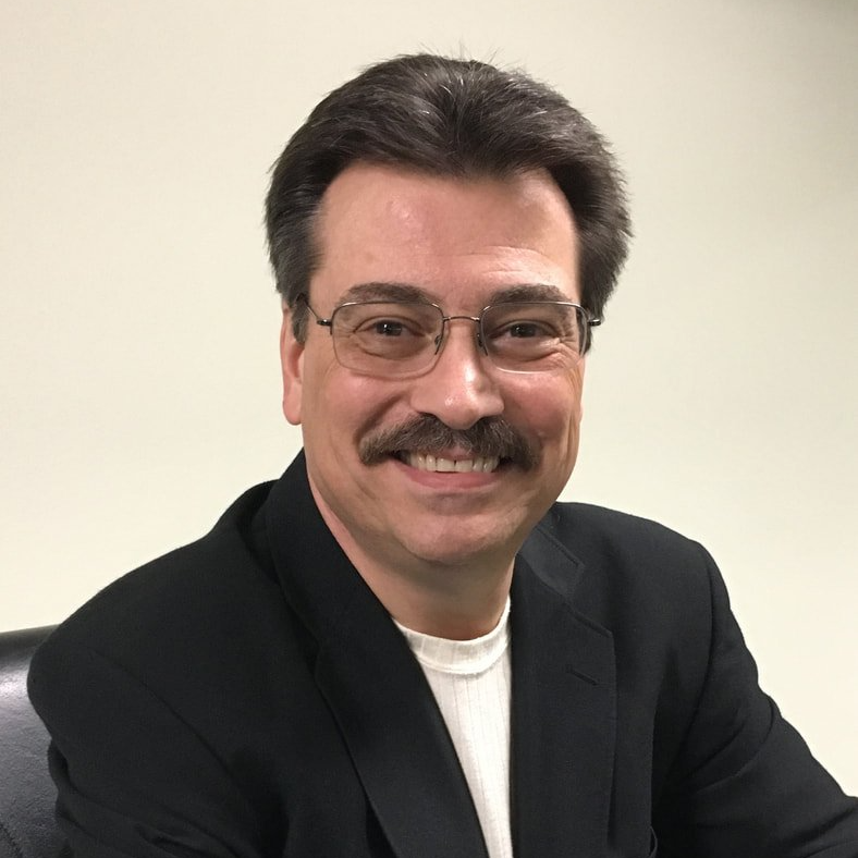 A man with glasses and a mustache is smiling for the camera