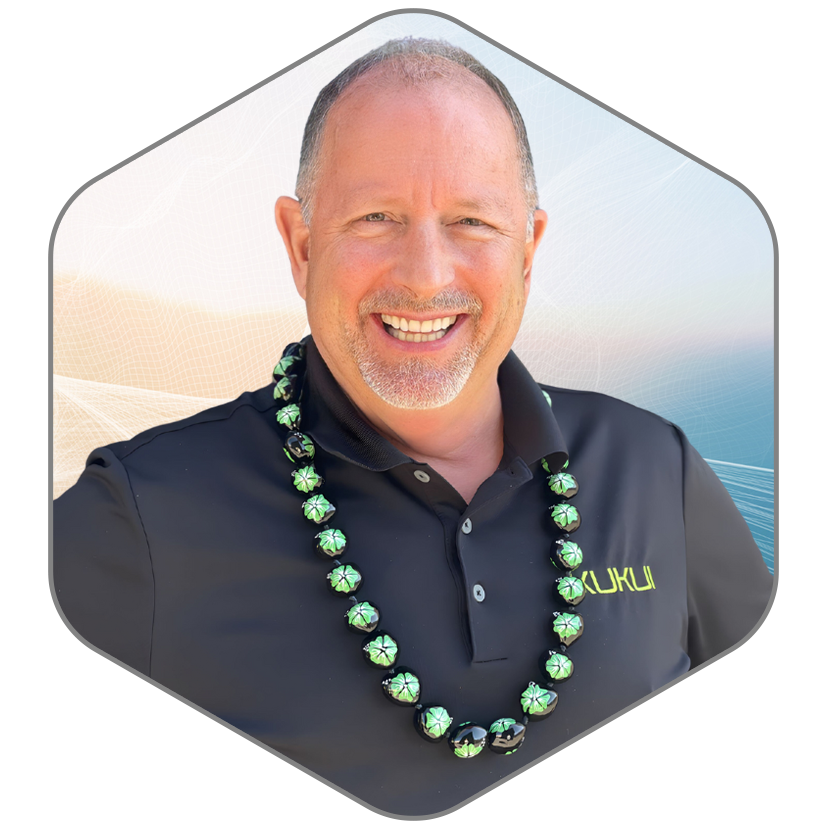 A man wearing a black shirt and a green necklace is smiling.