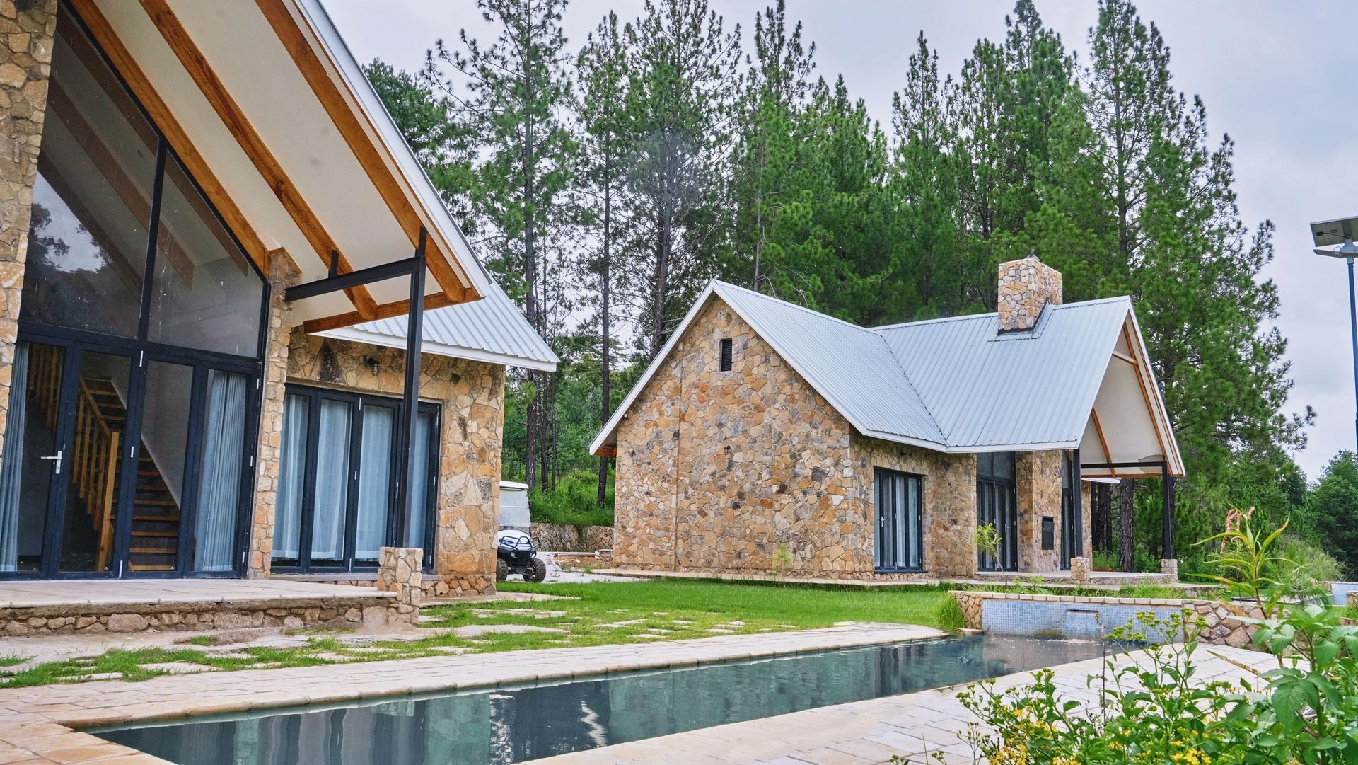 A stone house with a swimming pool in front of it.