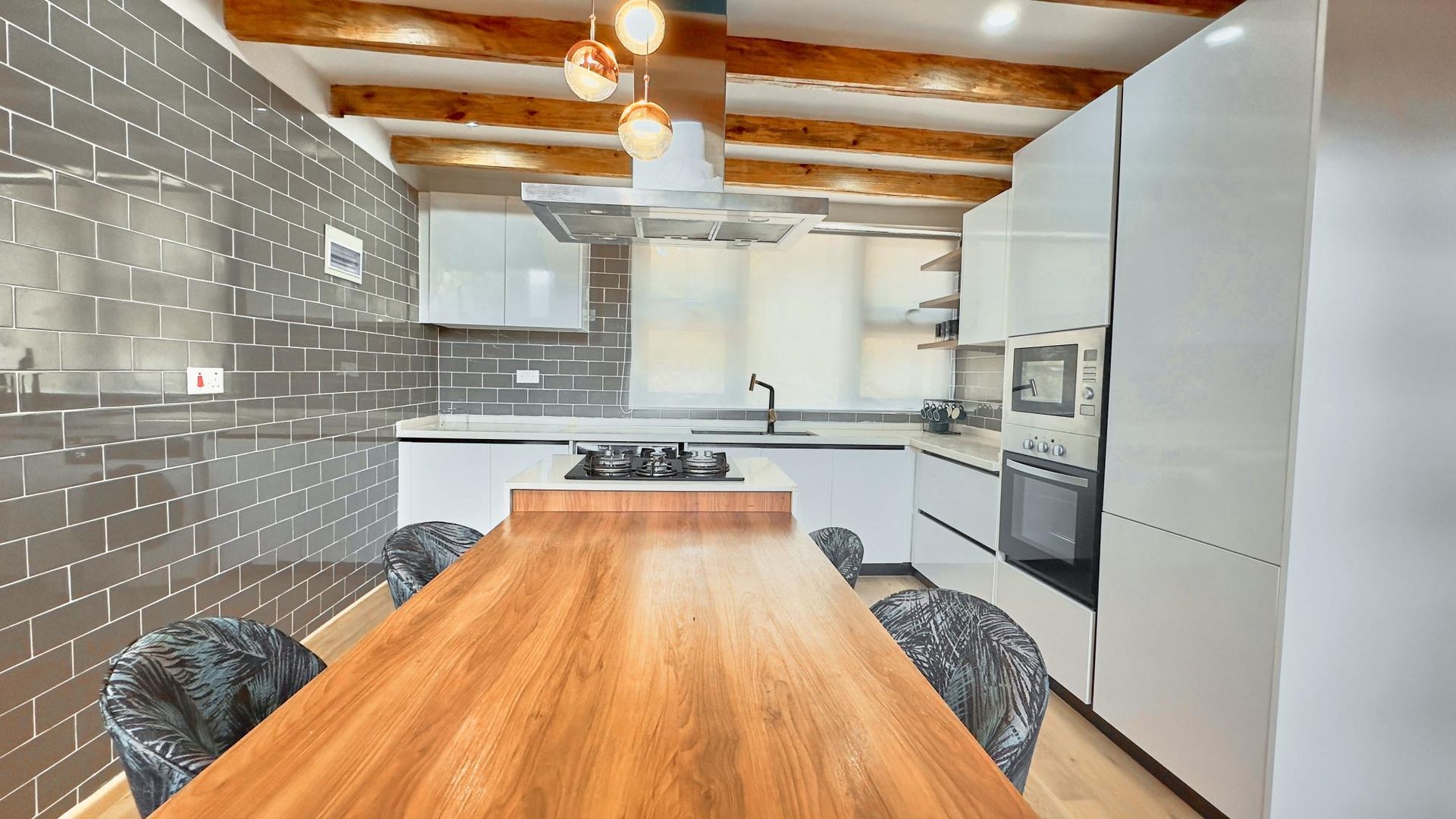 A kitchen with a long wooden table and chairs