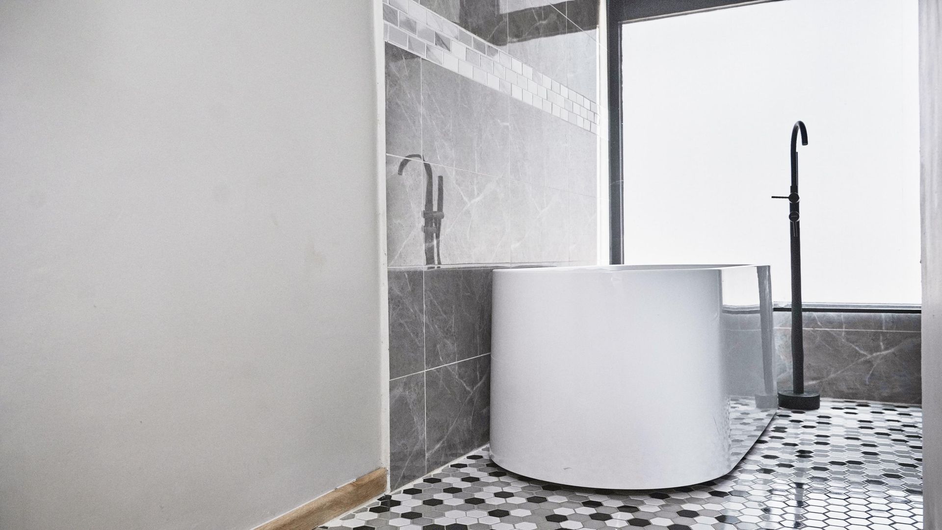 A bathroom with a bathtub and a window.