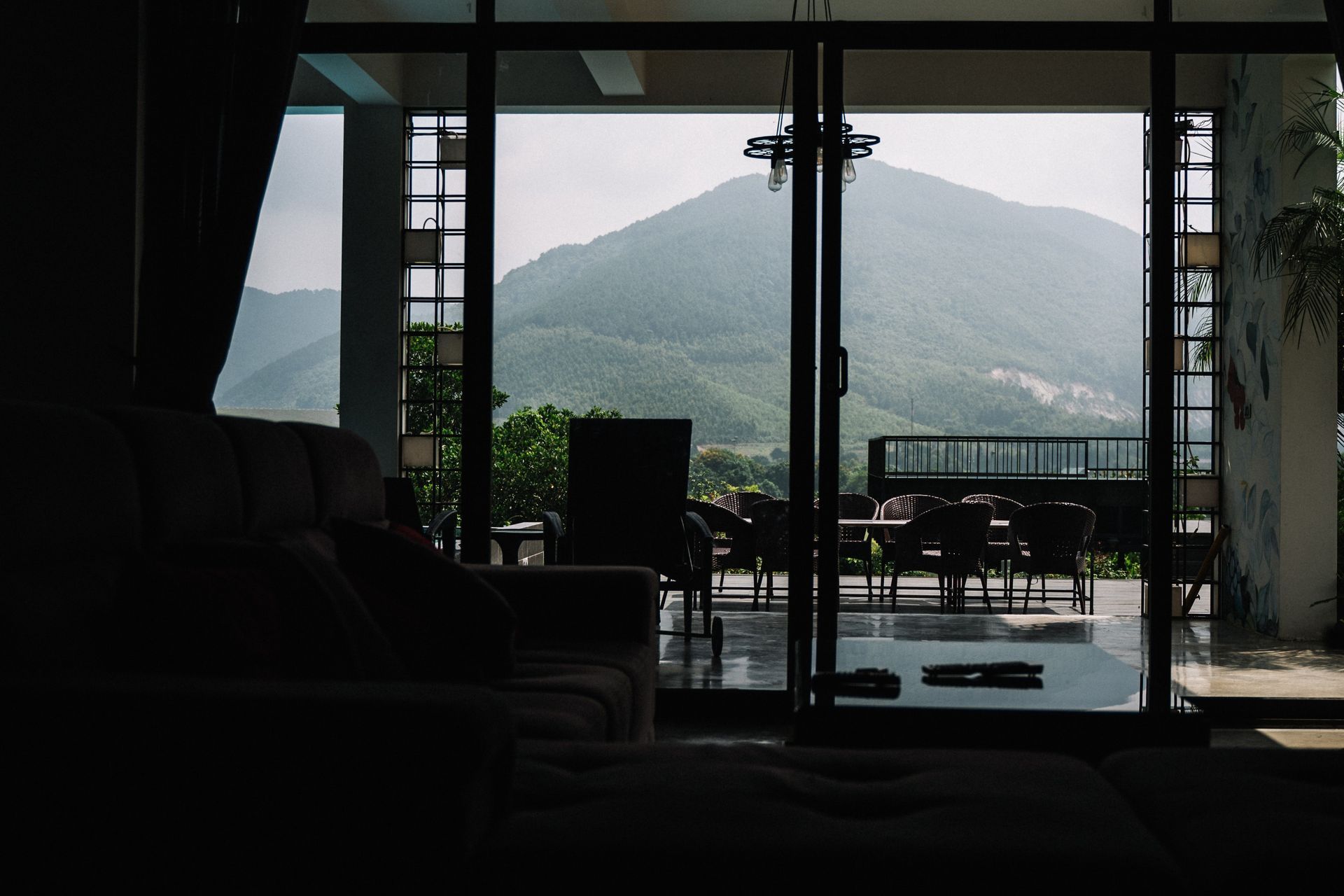 A living room with a view of mountains through a sliding glass door.