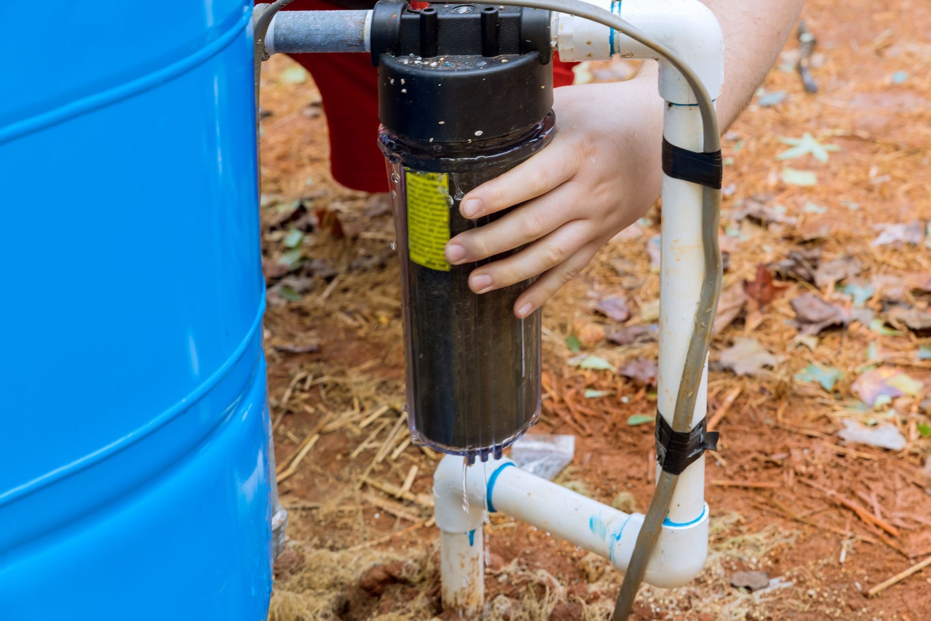 Technician servicing outdoor water filtration system. Technician servicing outdoor water filtration system.