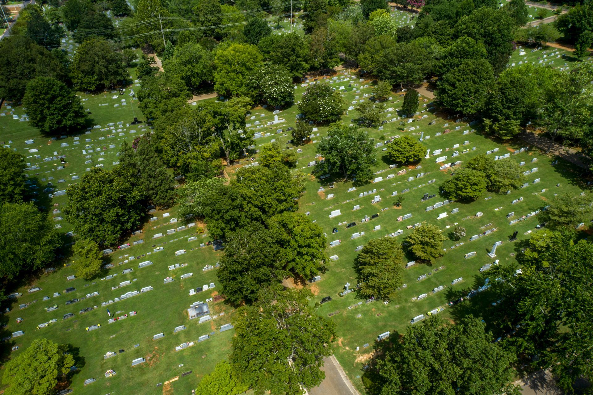 An aerial view of a cemetery surrounded by trees and grass.