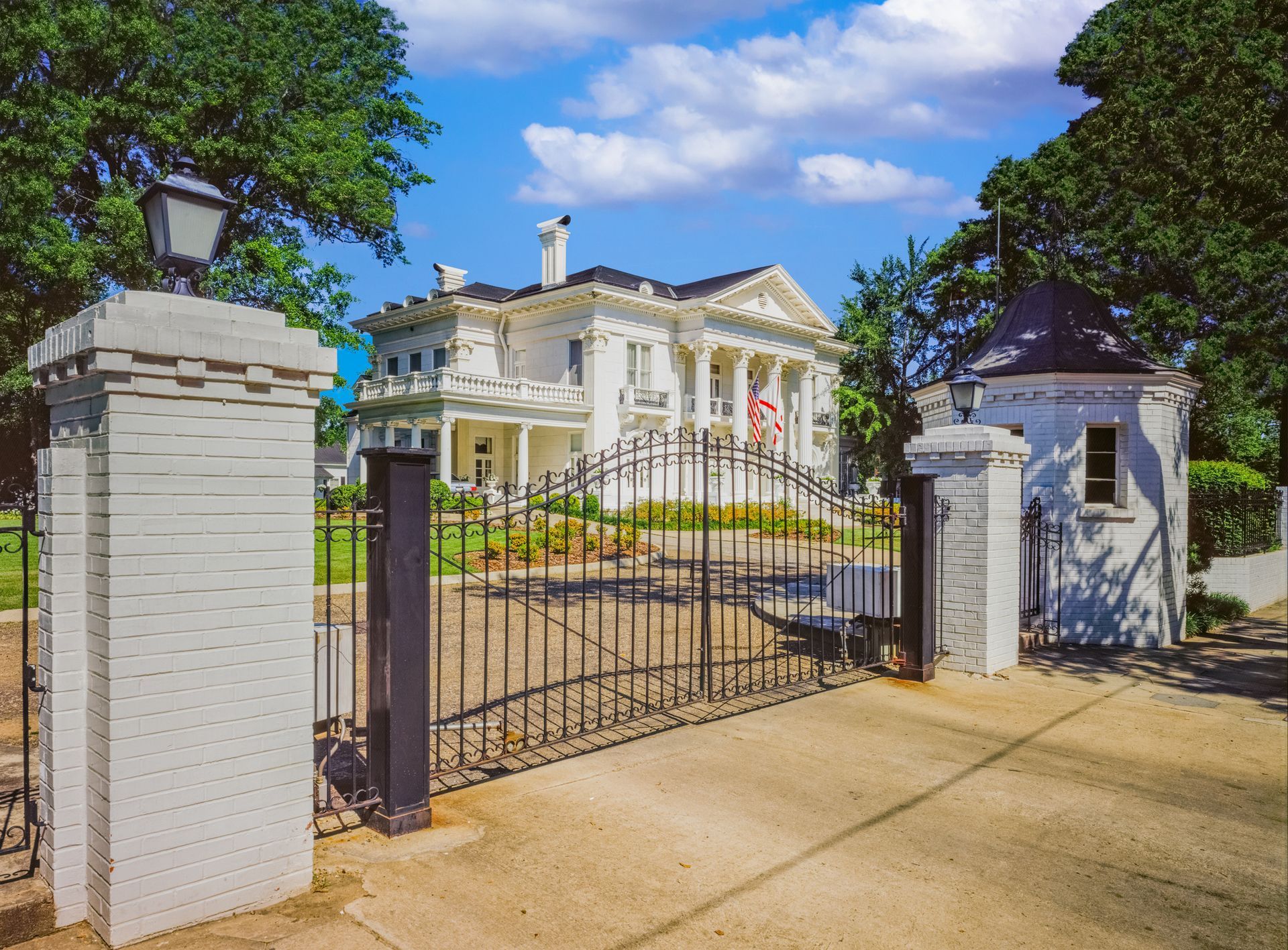 A large white house with a gate in front of it.