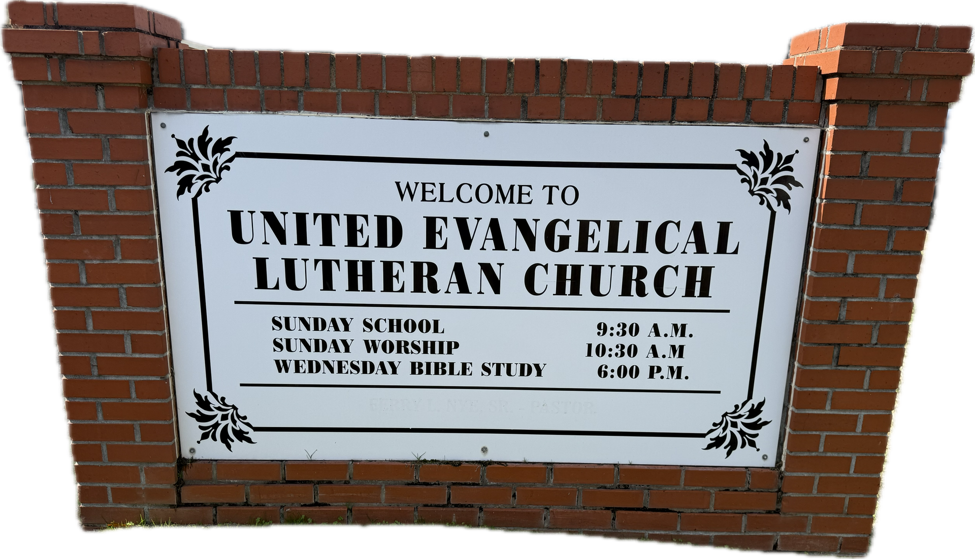 Rows of wooden benches in a church with a stained glass window in the background.