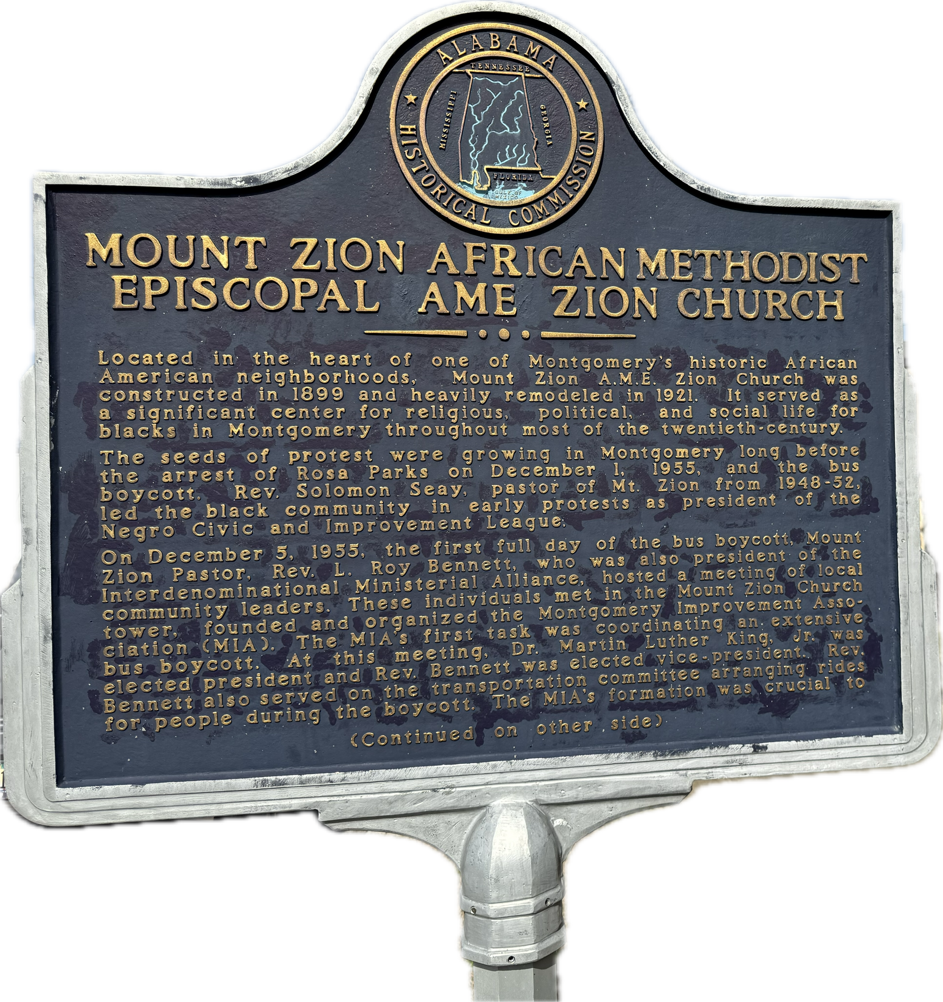 A stained glass window in a church with statues on the wall.