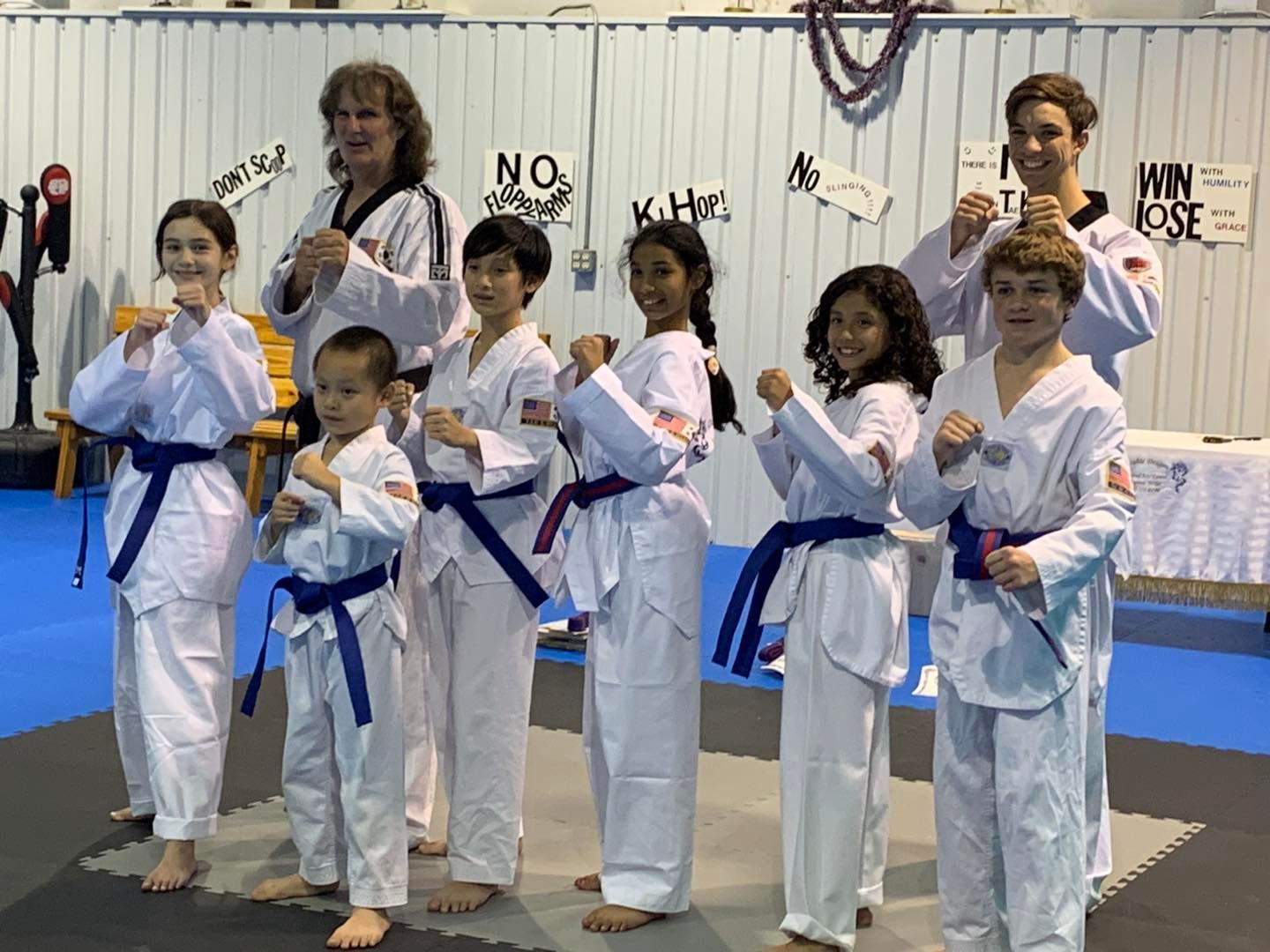 A group of young people in karate uniforms are posing for a picture.