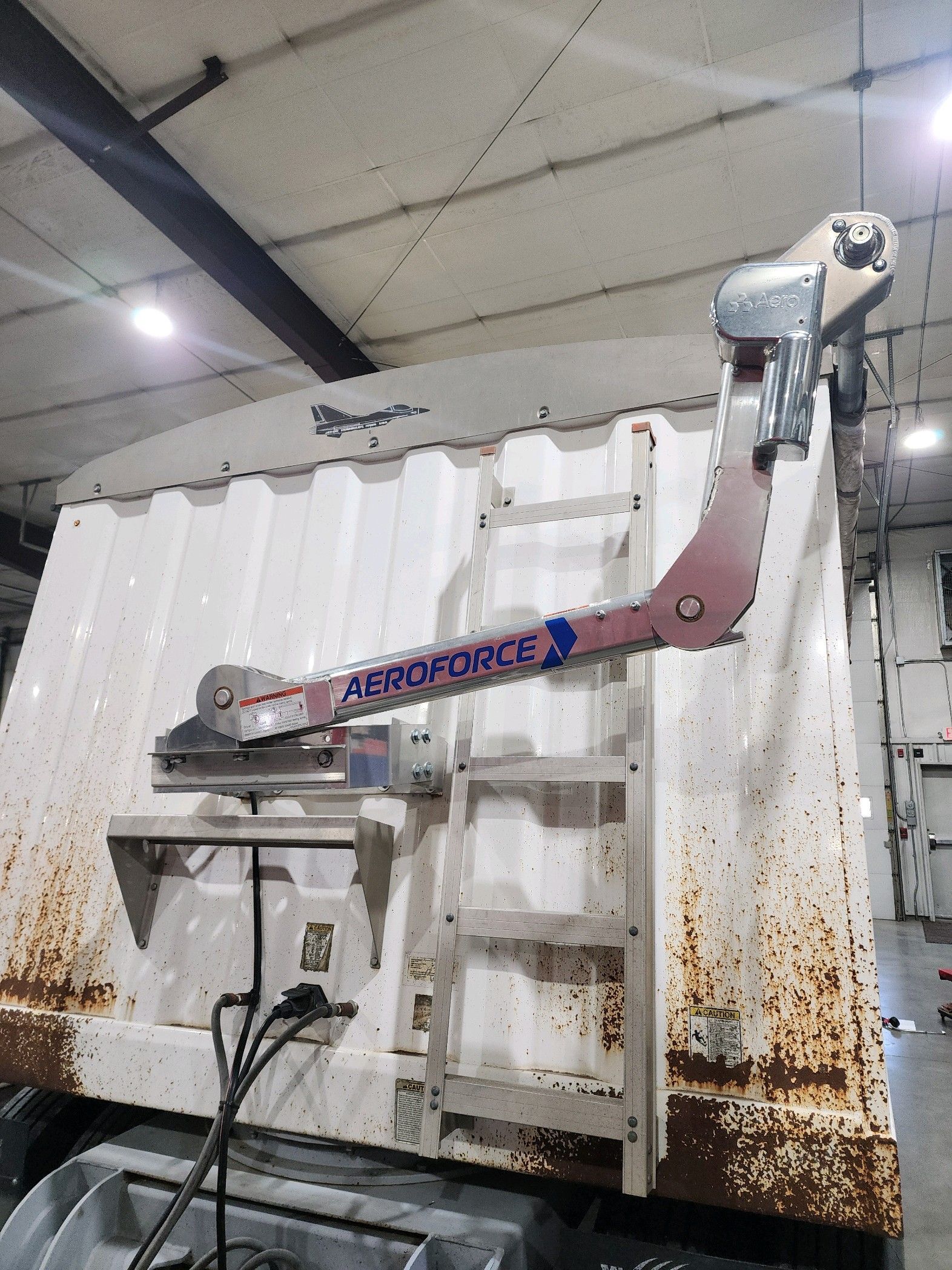 A dump truck with a ladder attached to the back of it.