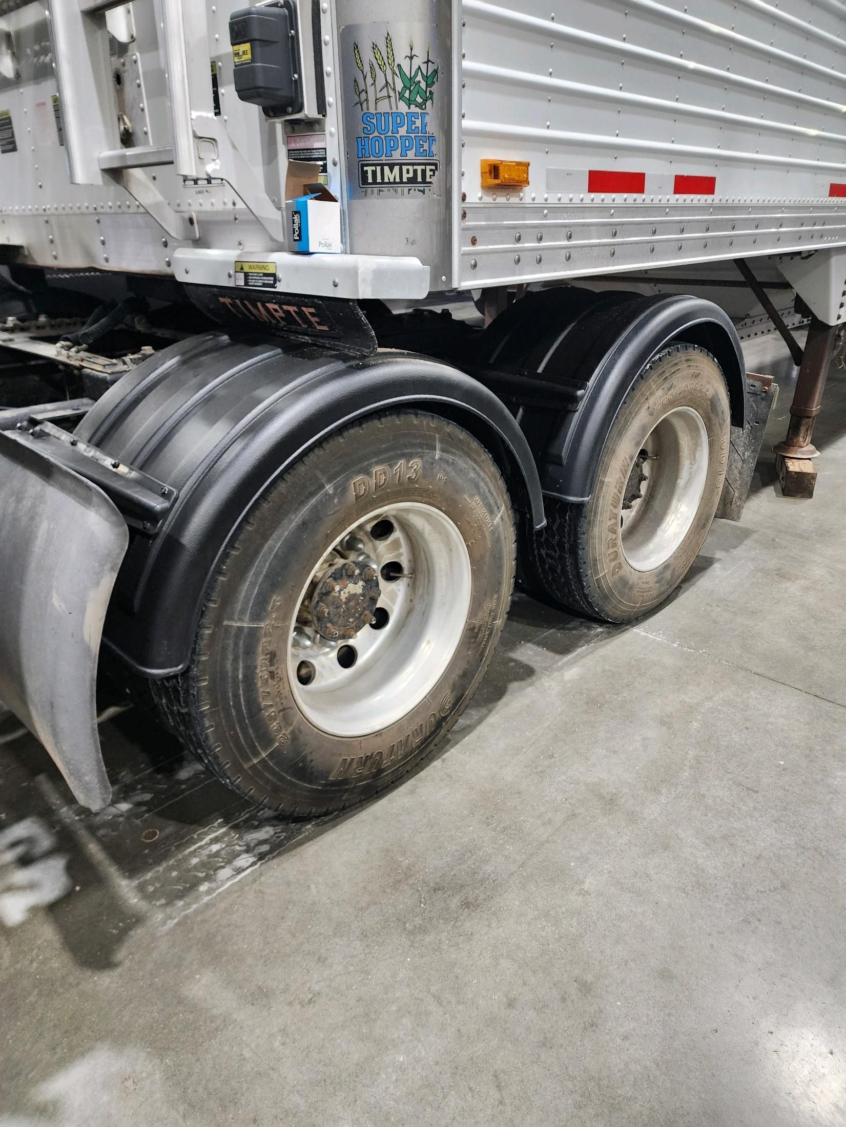 A semi truck with a trailer attached to it is parked in a garage.