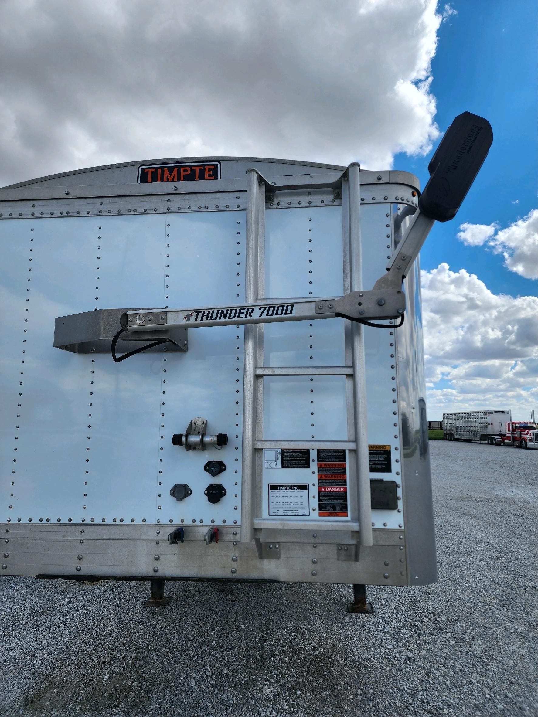 A white trailer with a ladder attached to the back