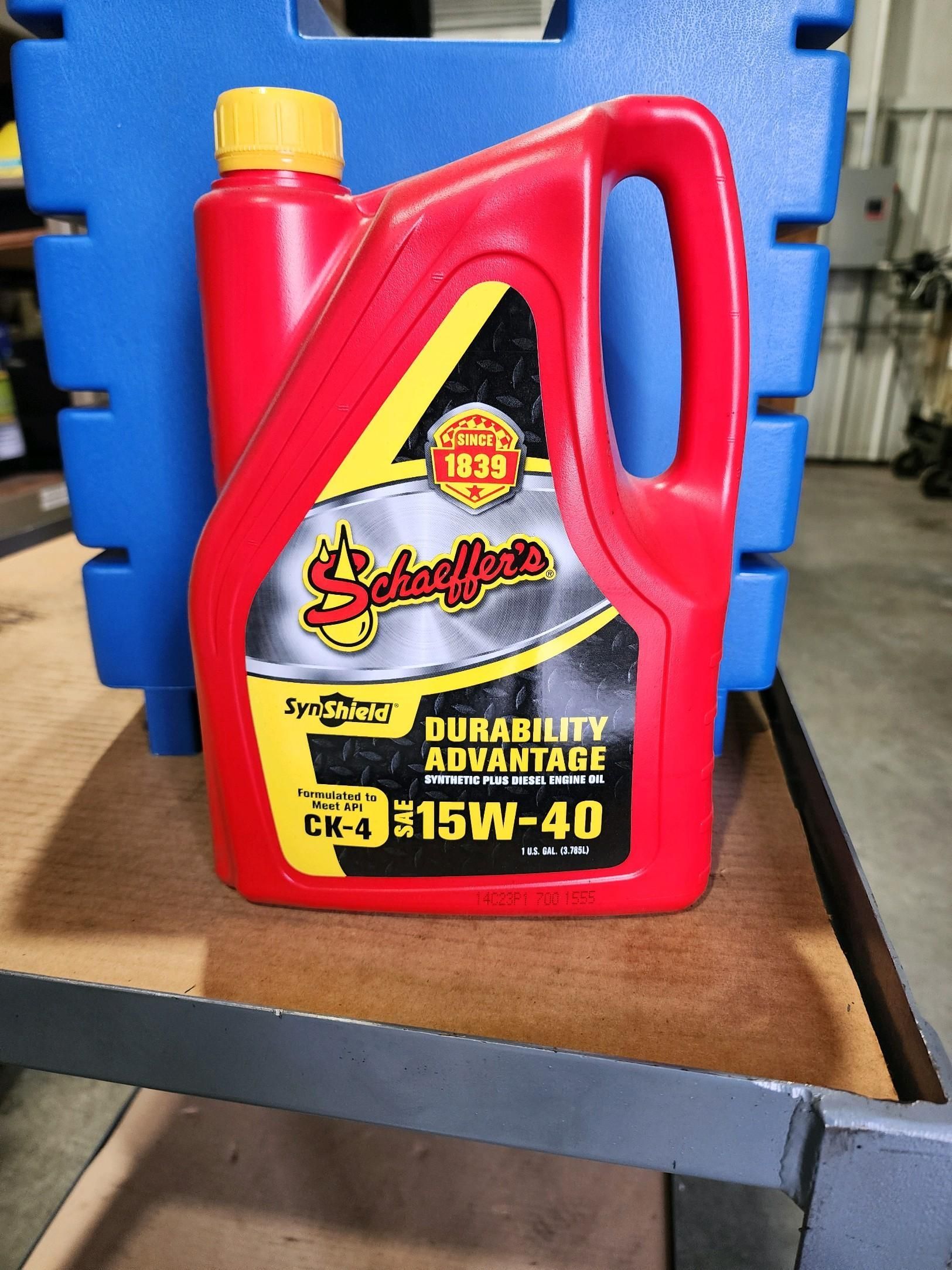 A gallon of oil is sitting on a shelf.