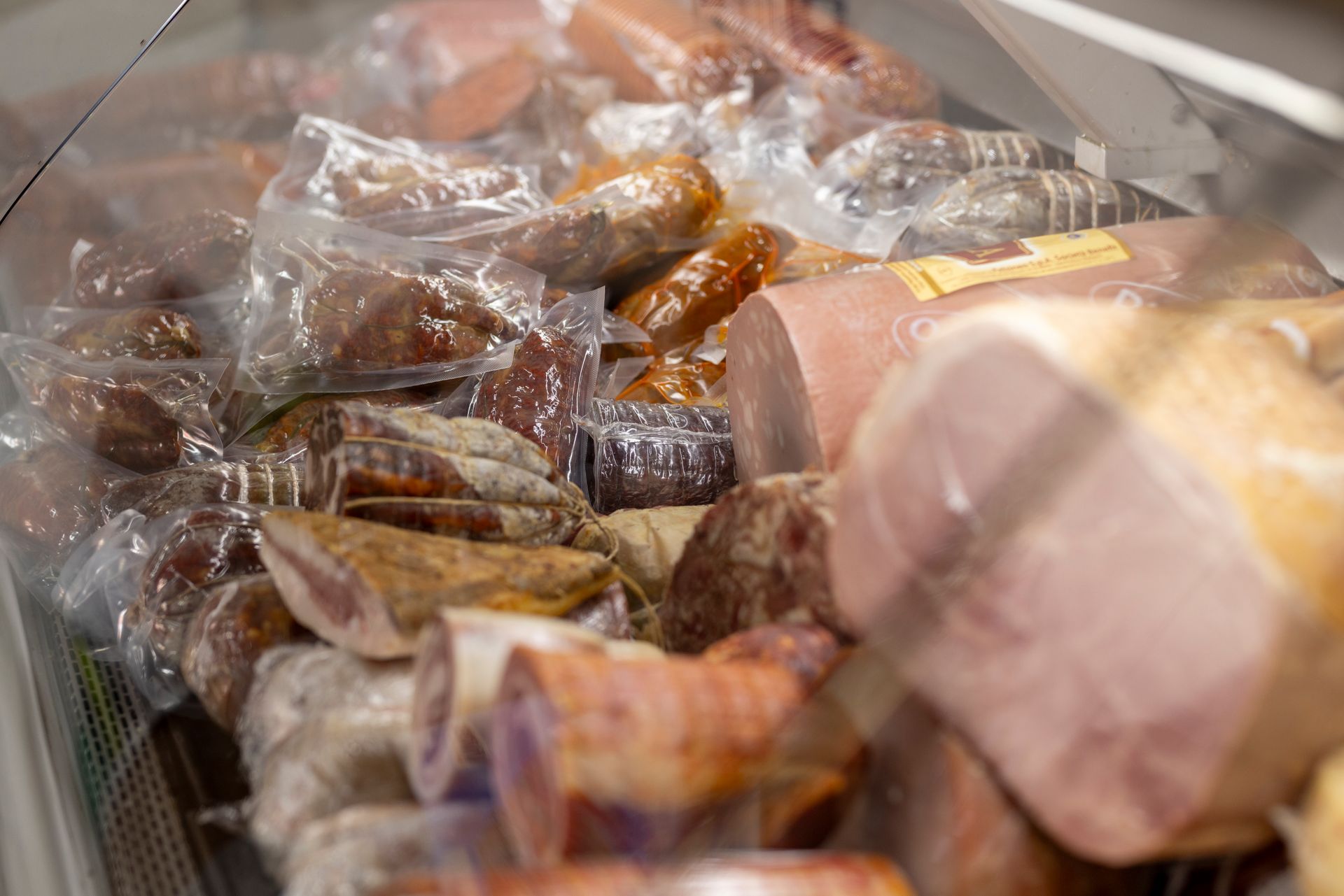 Una vetrina piena di carni e salsicce di vario tipo.