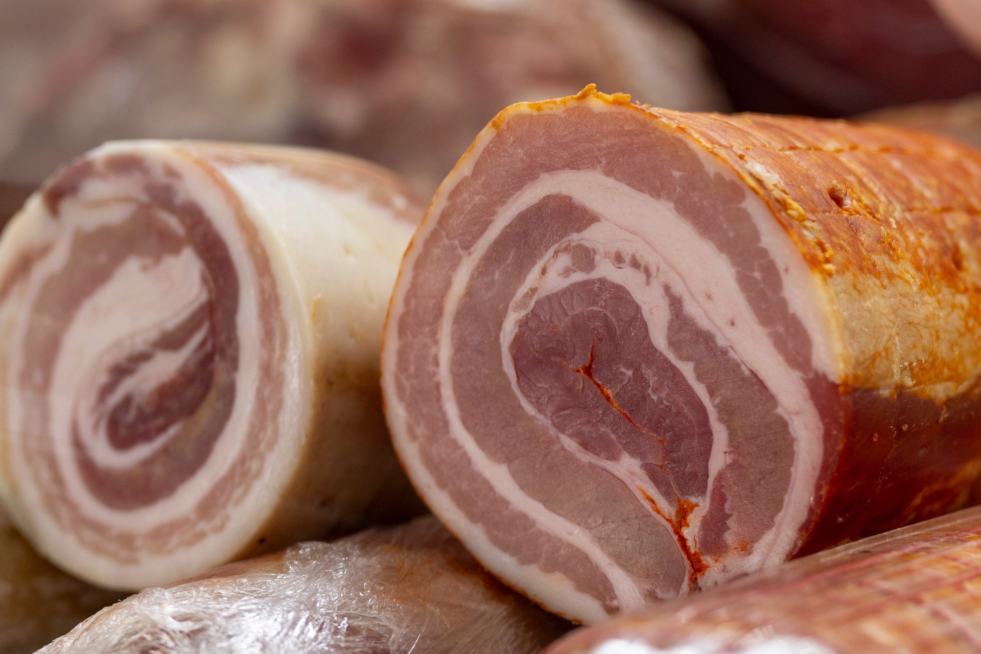 Primo piano di un rotolo di pancetta su un tavolo.