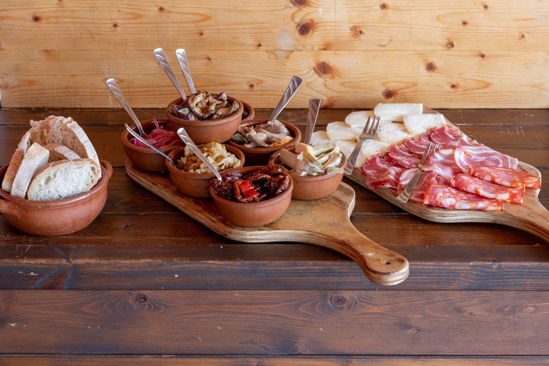 Un tavolo di legno sormontato da ciotole di cibo e carne.