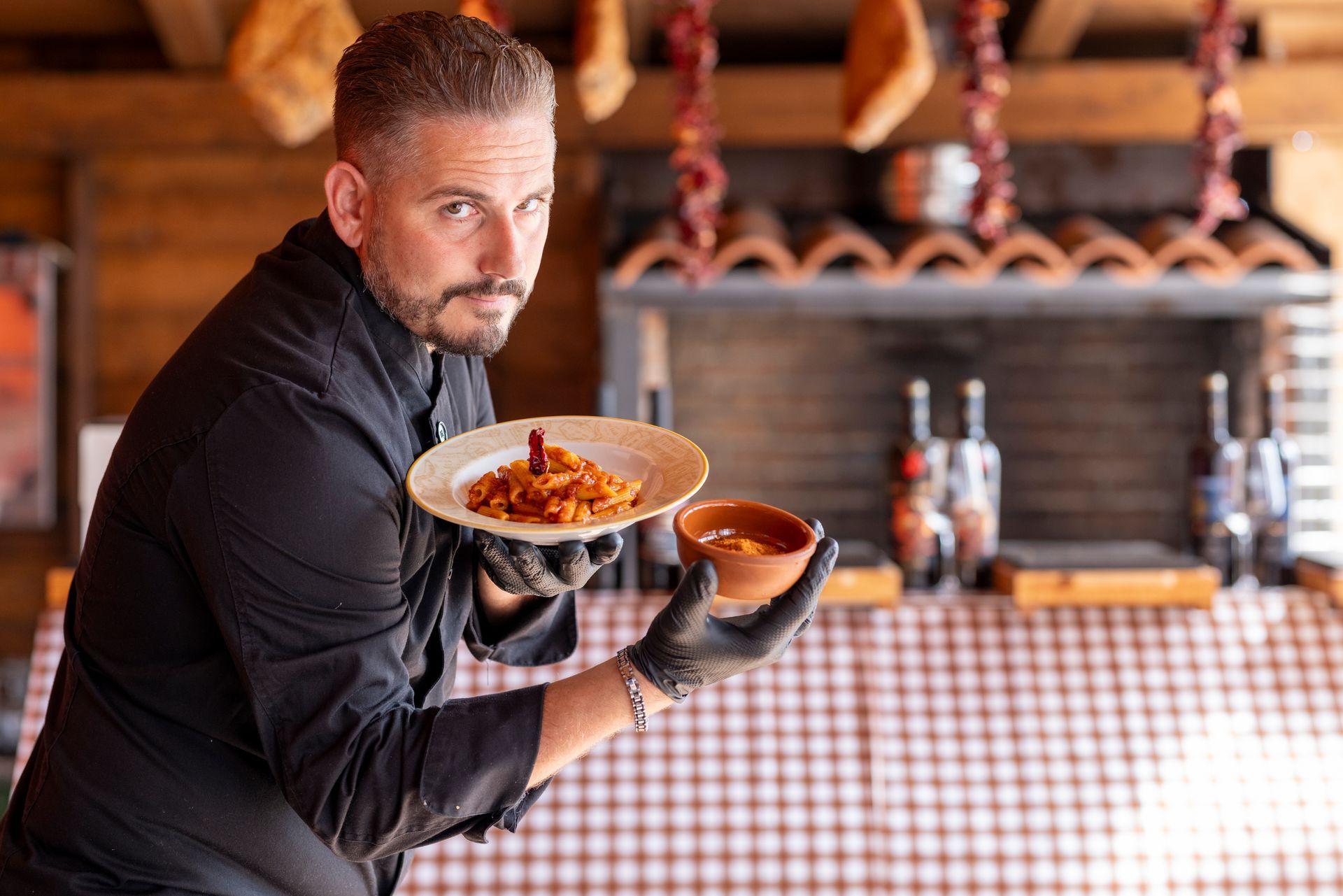 Un uomo tiene in mano un piatto di cibo e una ciotola di zuppa.