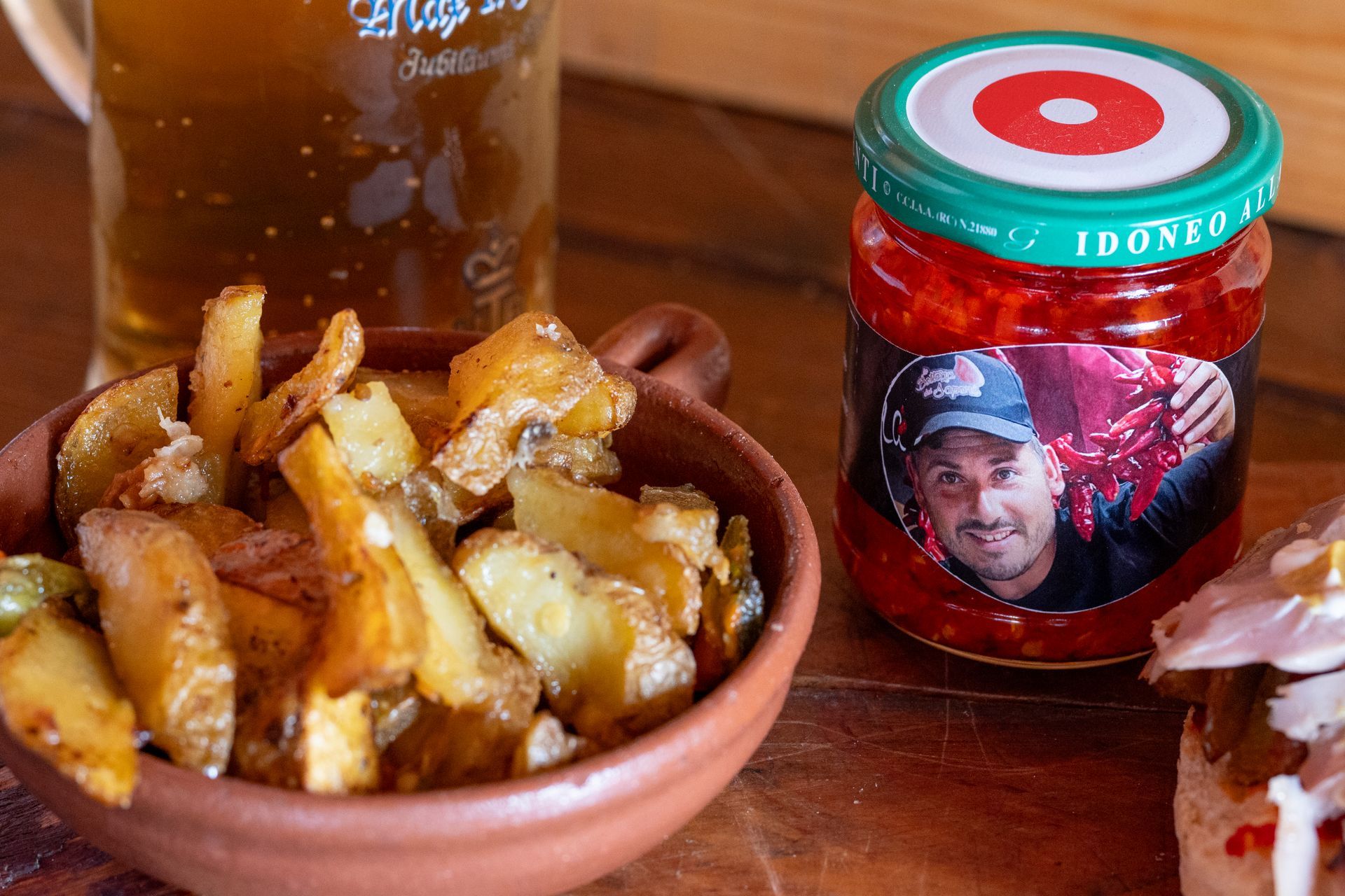 Una ciotola di patate accanto a un barattolo di salsa su un tavolo.