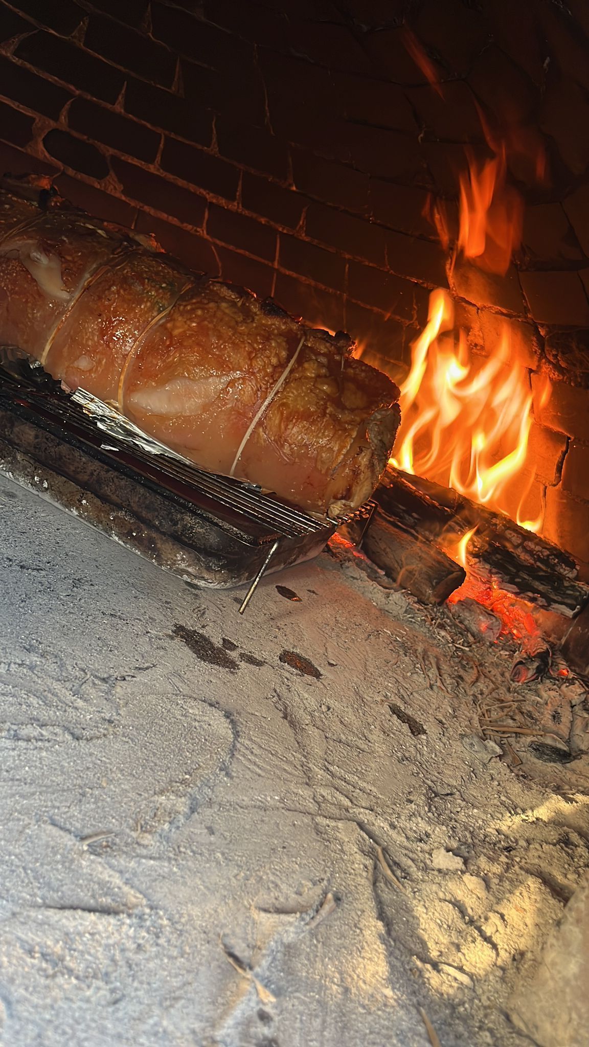 Un grosso pezzo di carne sta cuocendo nel camino.
