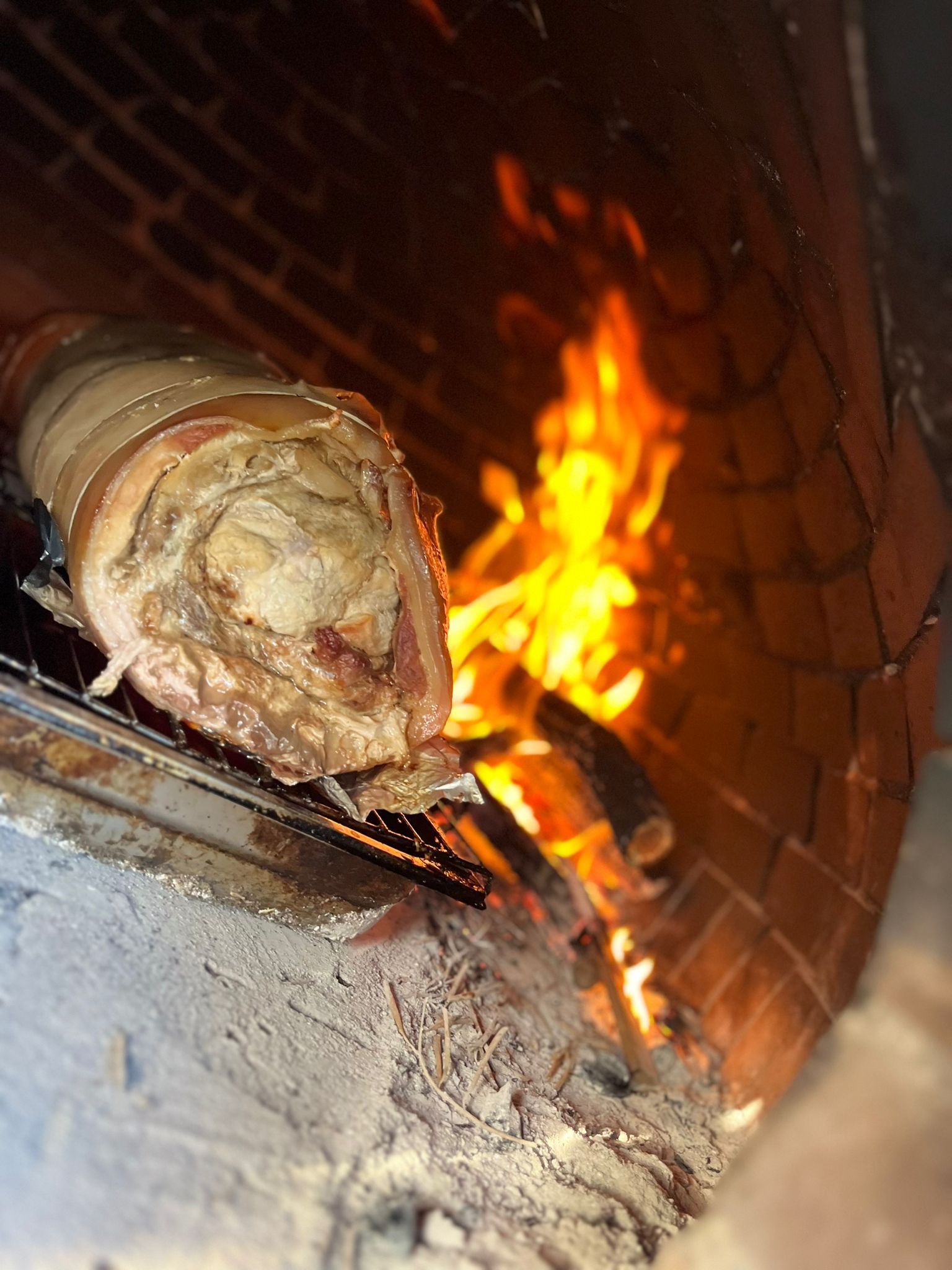 Un pezzo di carne viene cotto in un forno di mattoni.