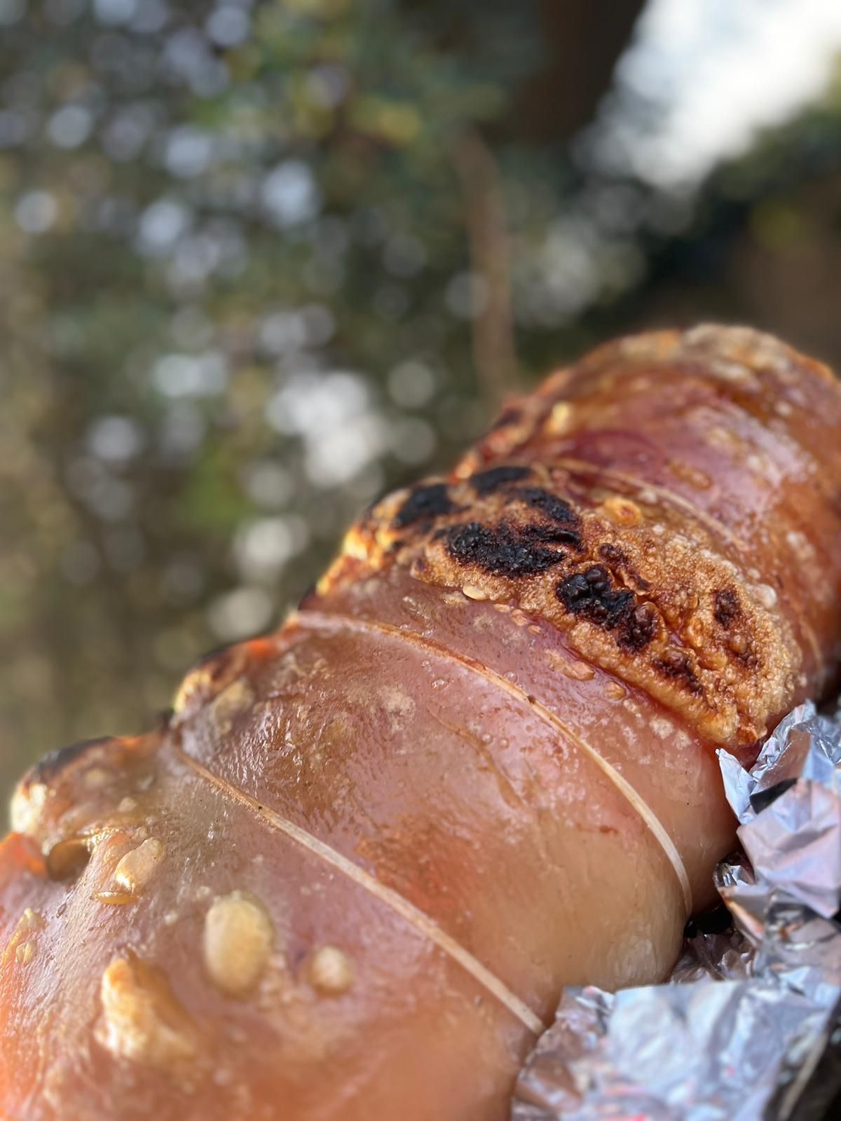 Primo piano di un pezzo di carne avvolto in un foglio di stagnola.