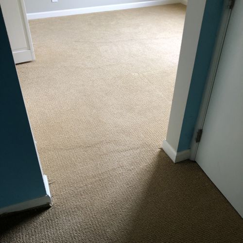 Beige carpeted room viewed from a doorway, with blue and white walls.