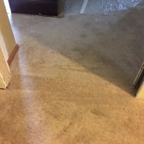 Tan-colored concrete floor with shadows and a doorway.