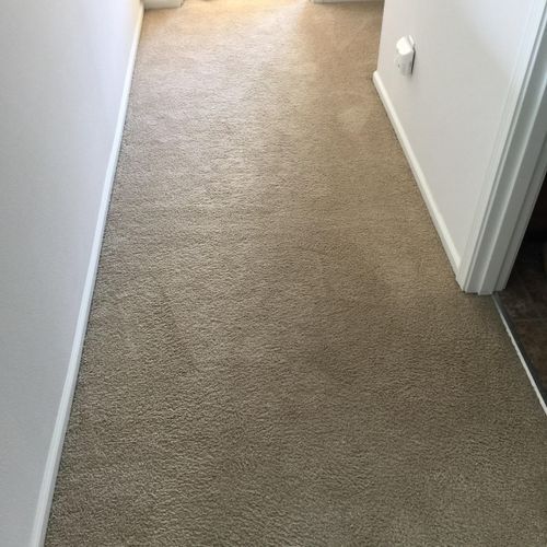 Narrow hallway with beige carpet and white walls.