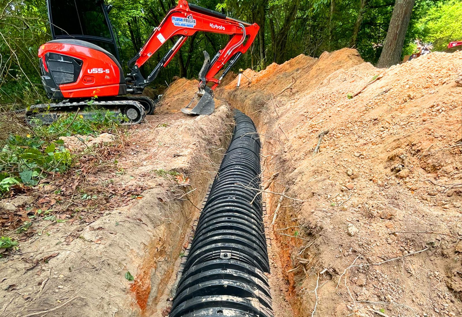 an excavator installing and repairing field lines on a septic system