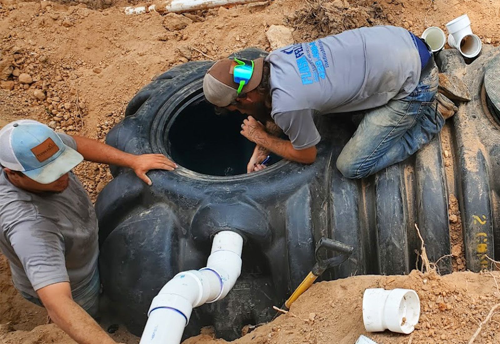 two employees installing a new construction septic tank