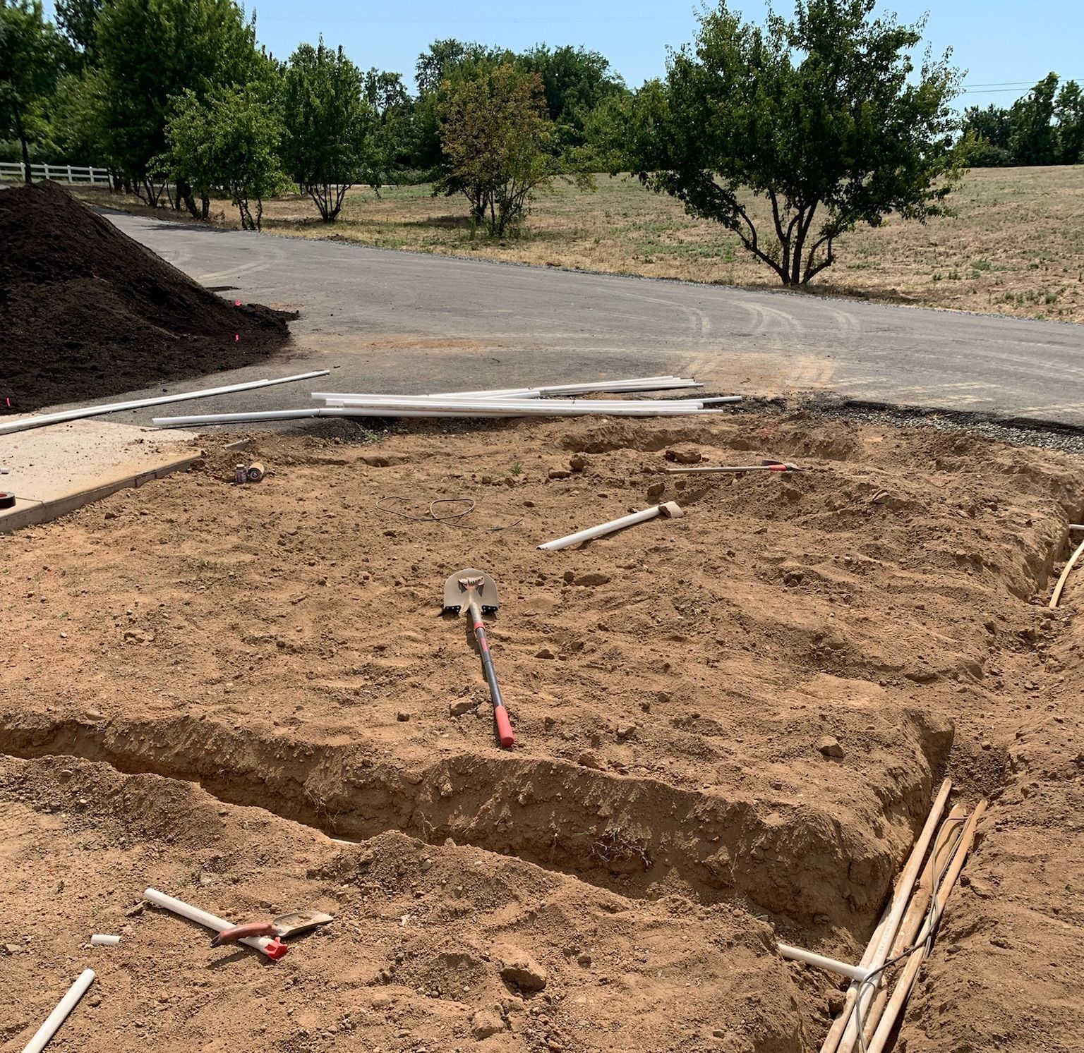 A pile of dirt is sitting on the side of a road.