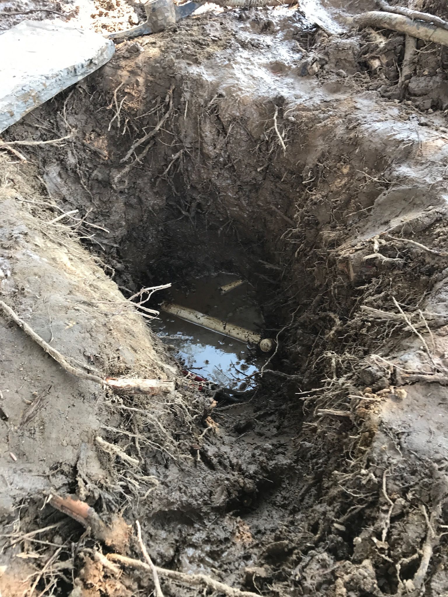 A hole in the ground with water coming out of it.