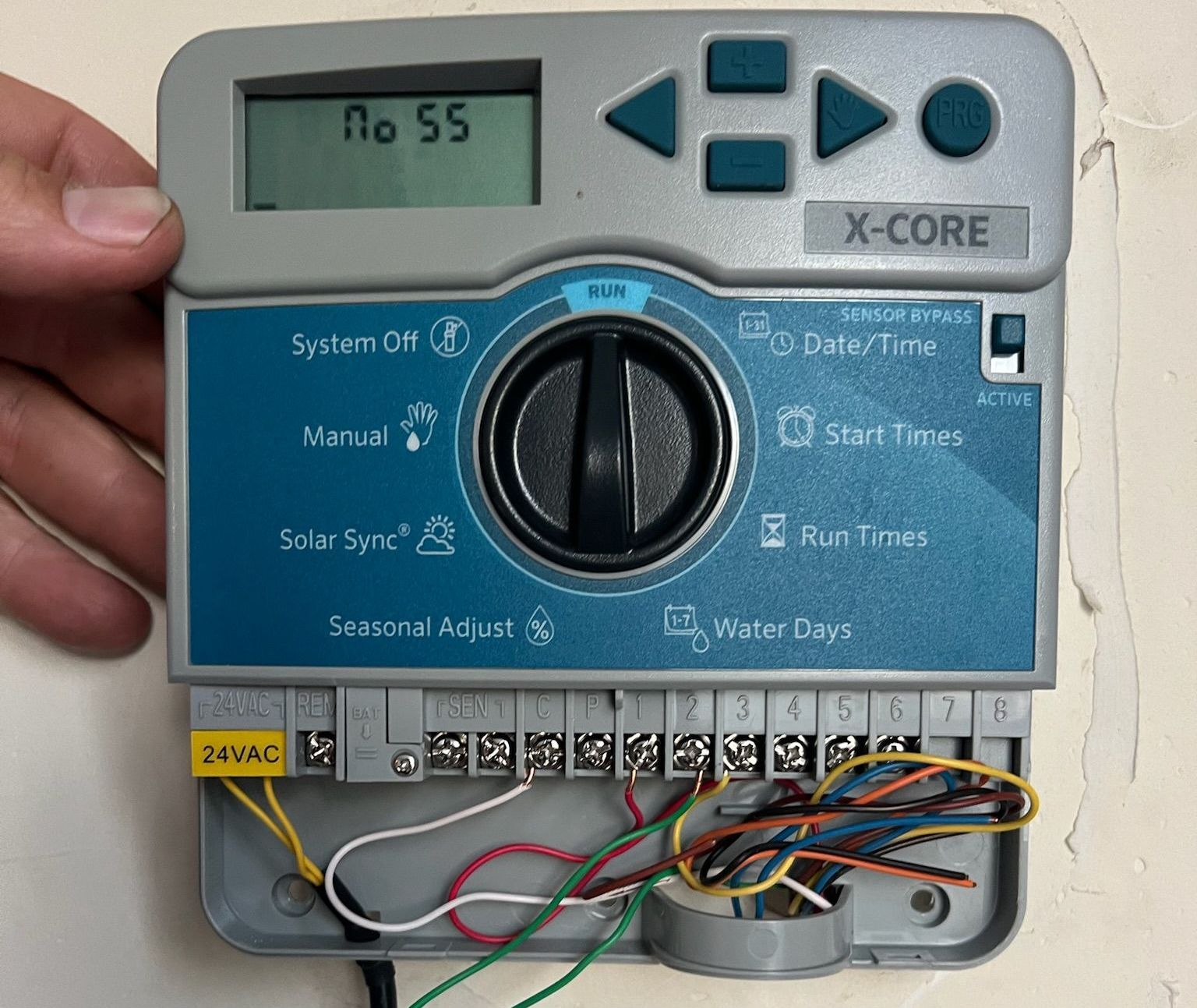 A person is holding a x-core irrigation controller