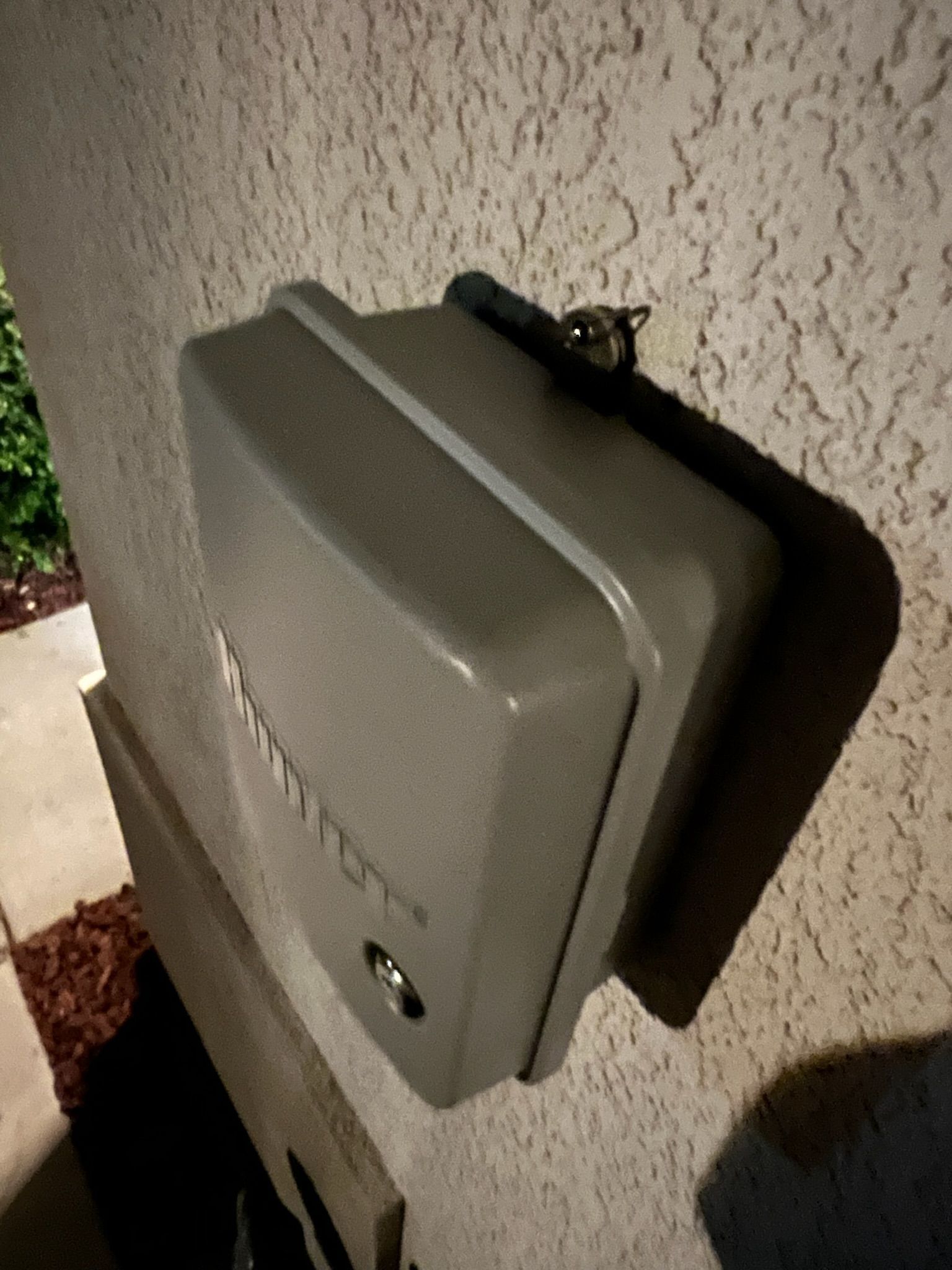 A gray box is sitting on the side of a building.