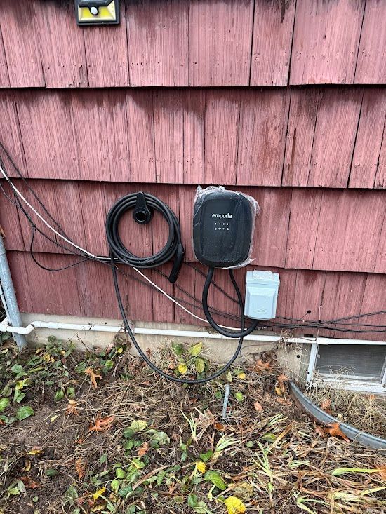 A charger is attached to the side of a house.