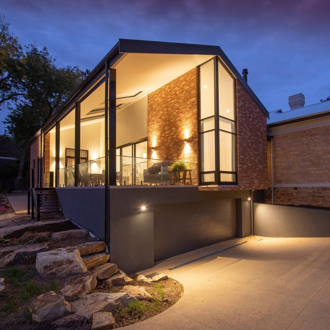 A house with a lot of windows is lit up at night